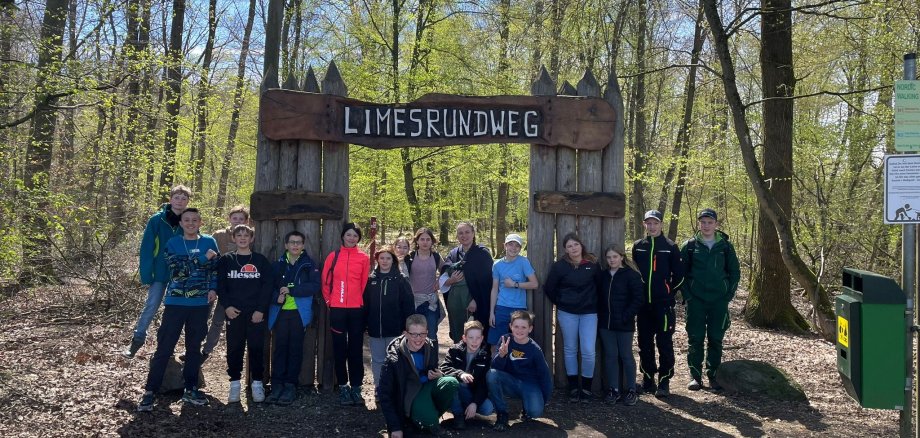 Eine Gruppe von Kindern vor dem Palisadeneingang zum Limesrundweg