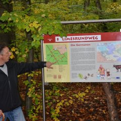 Herr Pfuhl vor einer Tafel des Limesrundwegs